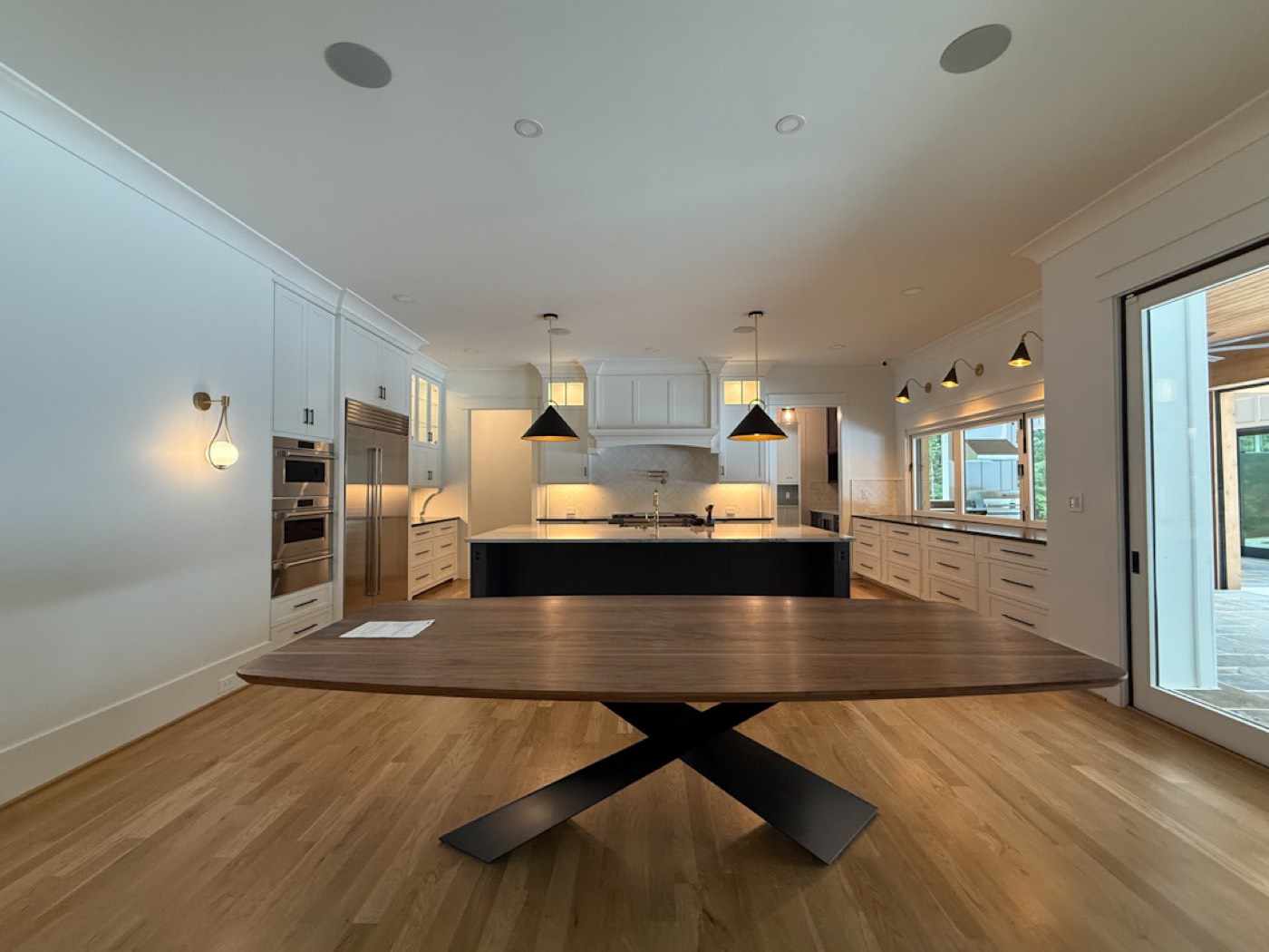 View from the dining room into a kitchen with two pendant lights hanging over the counter